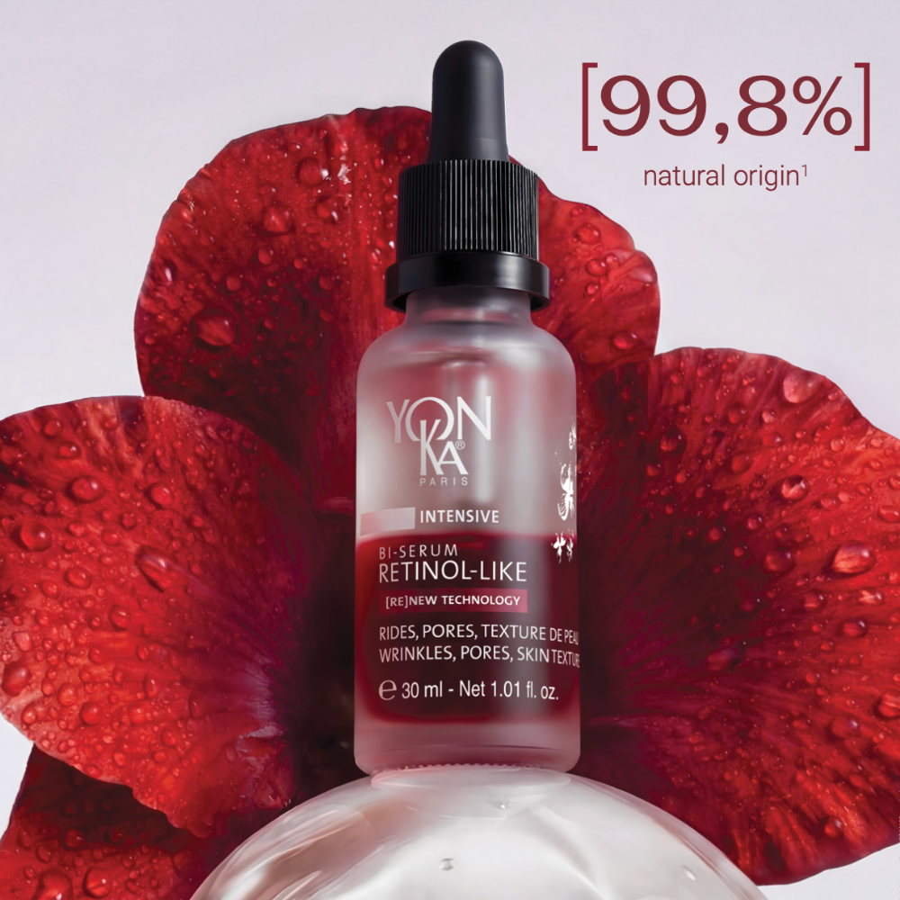 Cosmetic dropper bottle with red flower petals on a white background