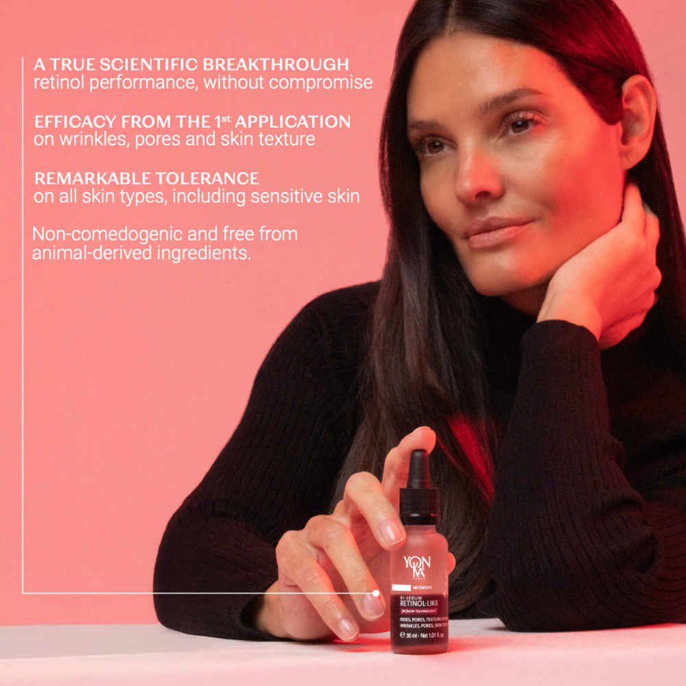 Woman holding a skincare bottle with product details on a pink background