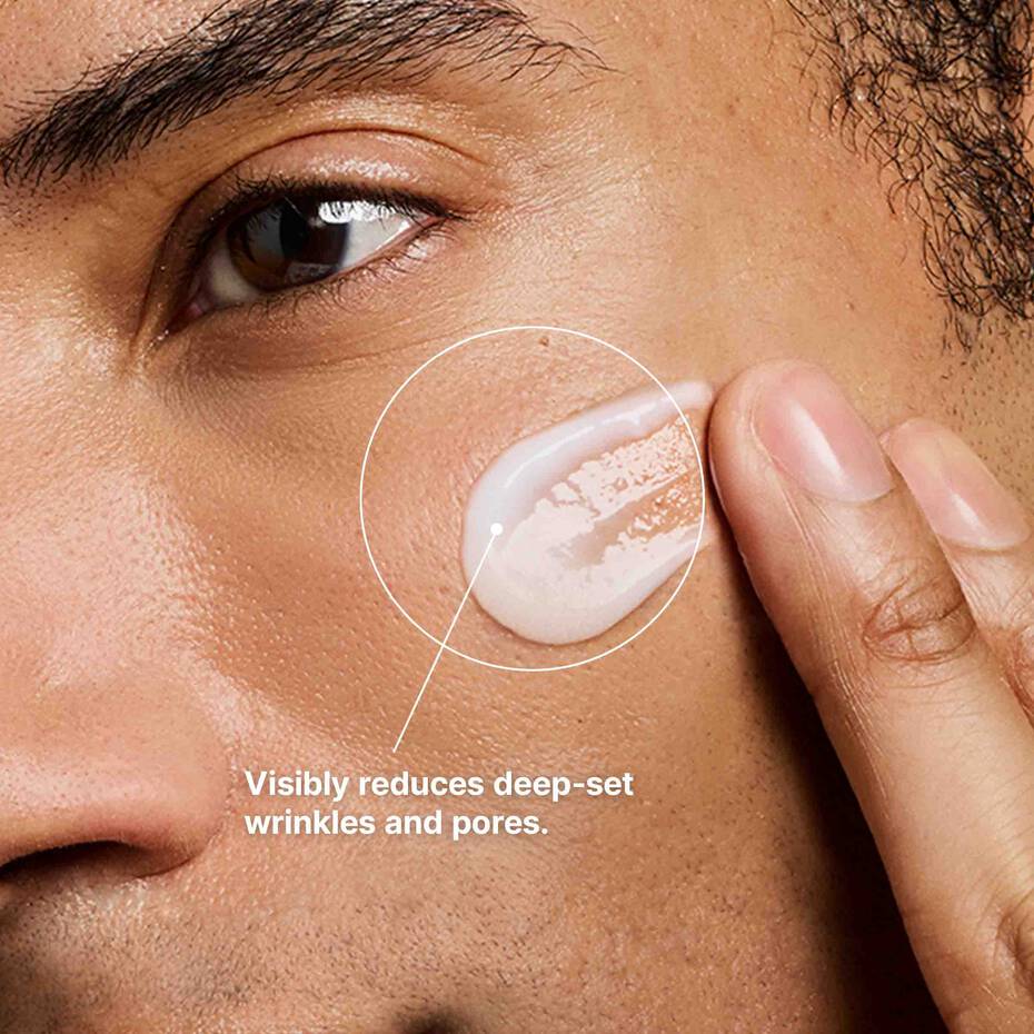 Close-up of a person applying cream to their face with text indicating it reduces deep-set wrinkles and pores.