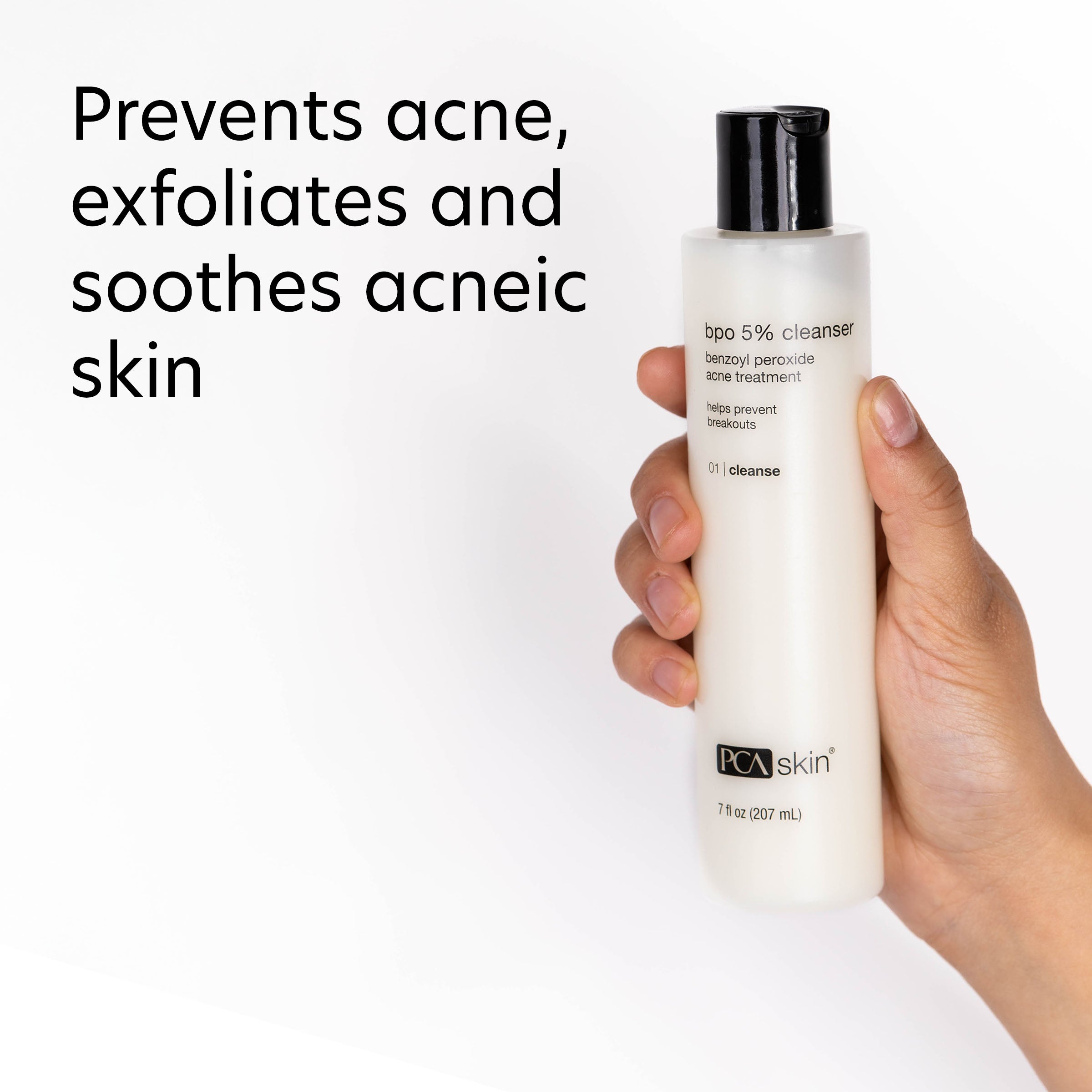 Hand holding a bottle of PCA Skin cleanser with text about its benefits on a white background
