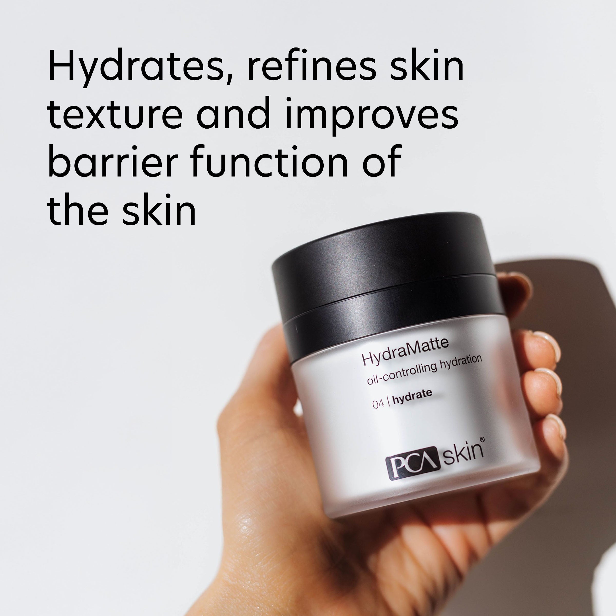 Hand holding a jar of PCX Skin HydraMatte product with text about skin benefits on a light background